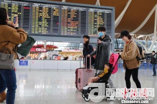 旅客帶著孩子前往辦票柜臺辦理登機手續(xù)。　殷立勤 攝