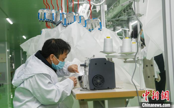 工人生產(chǎn)防護服，保障抗疫物資供應(yīng)。廣安市委宣傳部供圖