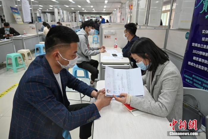 4月14日，招聘者在查看求職者簡歷。<a target='_blank'  data-cke-saved- >中新社</a>記者 王剛 攝