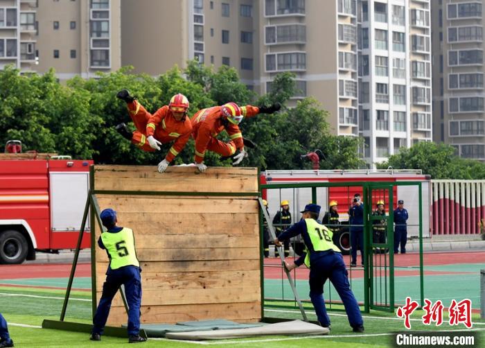 新消防員進(jìn)行消防障礙接力操展示?！⒅铱?攝