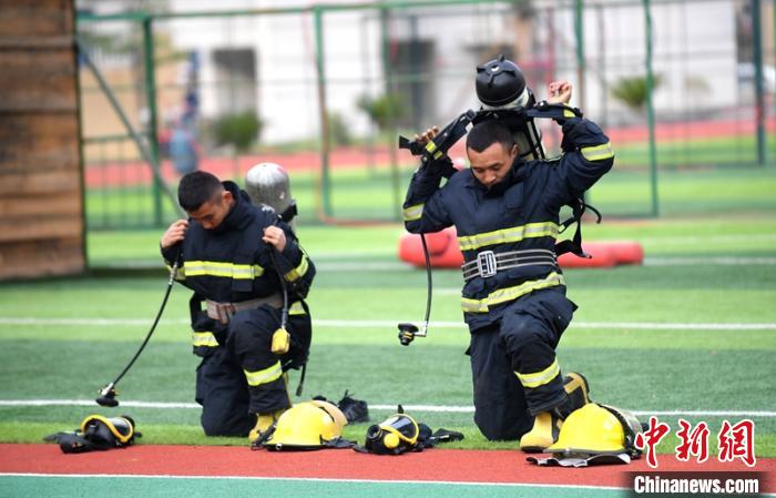 新消防員進(jìn)行穿戴空呼器展示?！⒅铱?攝