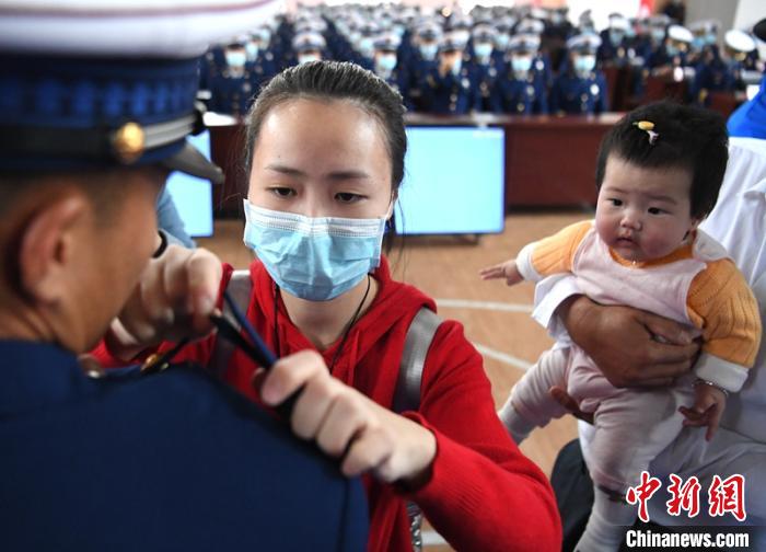 新消防員楊振的妻子彭莉與女兒現(xiàn)場(chǎng)見(jiàn)證丈夫加入“火焰藍(lán)”的神圣時(shí)刻?！⒅铱?攝