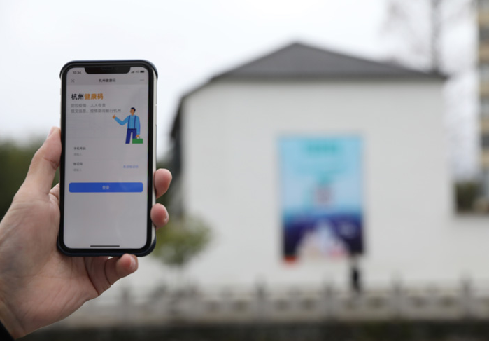 在浙江省杭州市臨安區(qū)天目山鎮(zhèn)，一名居民在“杭州健康碼”海報上掃碼申領(lǐng)個人二維碼。新華社發(fā)