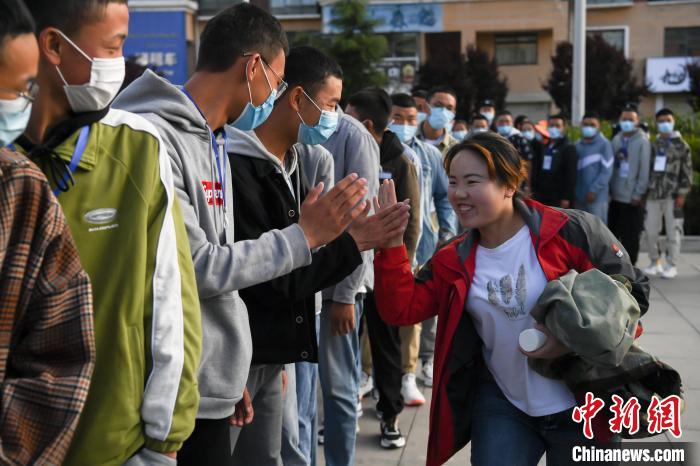 7月7日，拉薩三高考點(diǎn)外，領(lǐng)隊(duì)老師與考生擊掌鼓勁加油?！『闻罾?攝