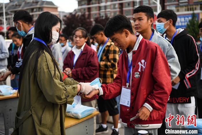 7月7日，考生在拉薩三高考點(diǎn)外測(cè)量體溫。　何蓬磊 攝