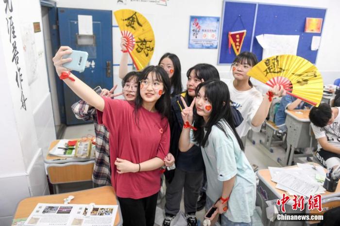 資料圖：6月6日，2021年高考前夕，湖南長沙同升湖實驗學校高三年級，考生們在教室內(nèi)合影。 楊華峰 攝