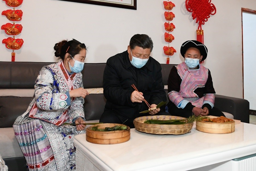 2021年2月3日下午，習(xí)近平在貴州畢節(jié)市黔西縣新仁苗族鄉(xiāng)化屋村苗族村民趙玉學(xué)家，同一家人邊聊家常邊制作當(dāng)?shù)貍鹘y(tǒng)節(jié)日食品黃粑。新華社記者 李學(xué)仁 攝